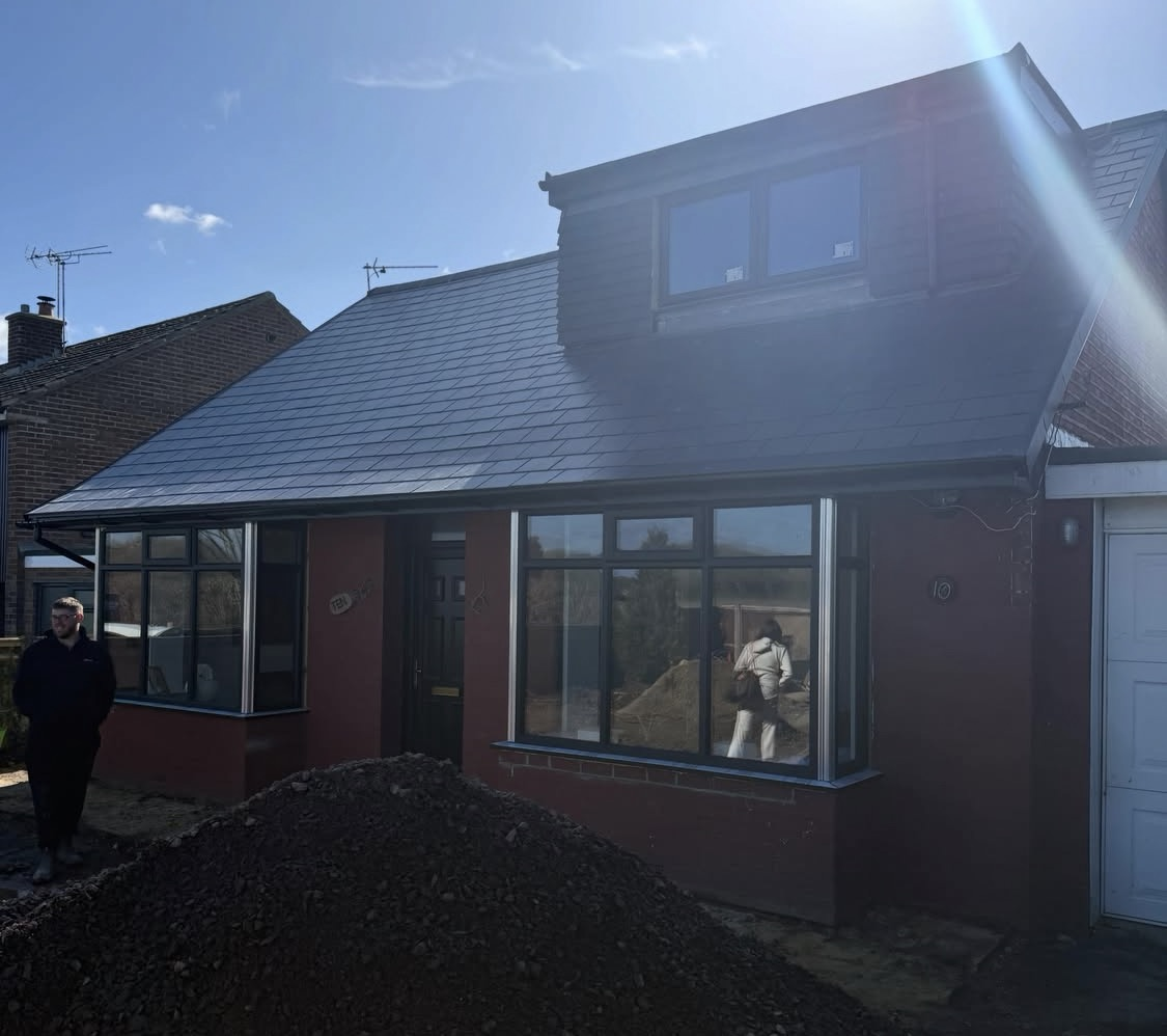 After: newly rendered front with a new roof and dormer
