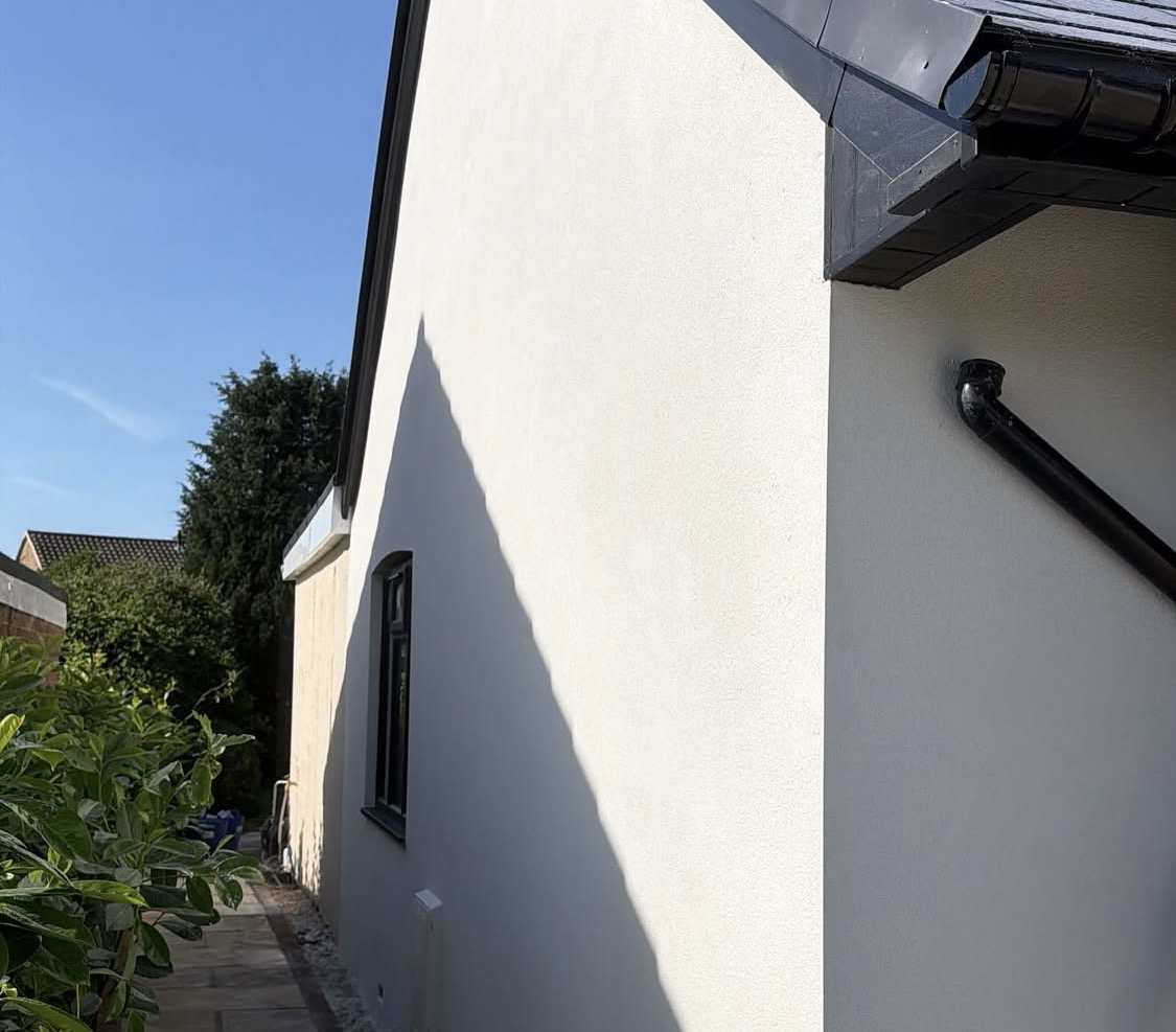 After: smooth white render wrapped neatly around the property
