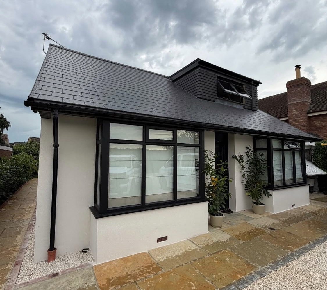 After: white render and black-framed windows completed