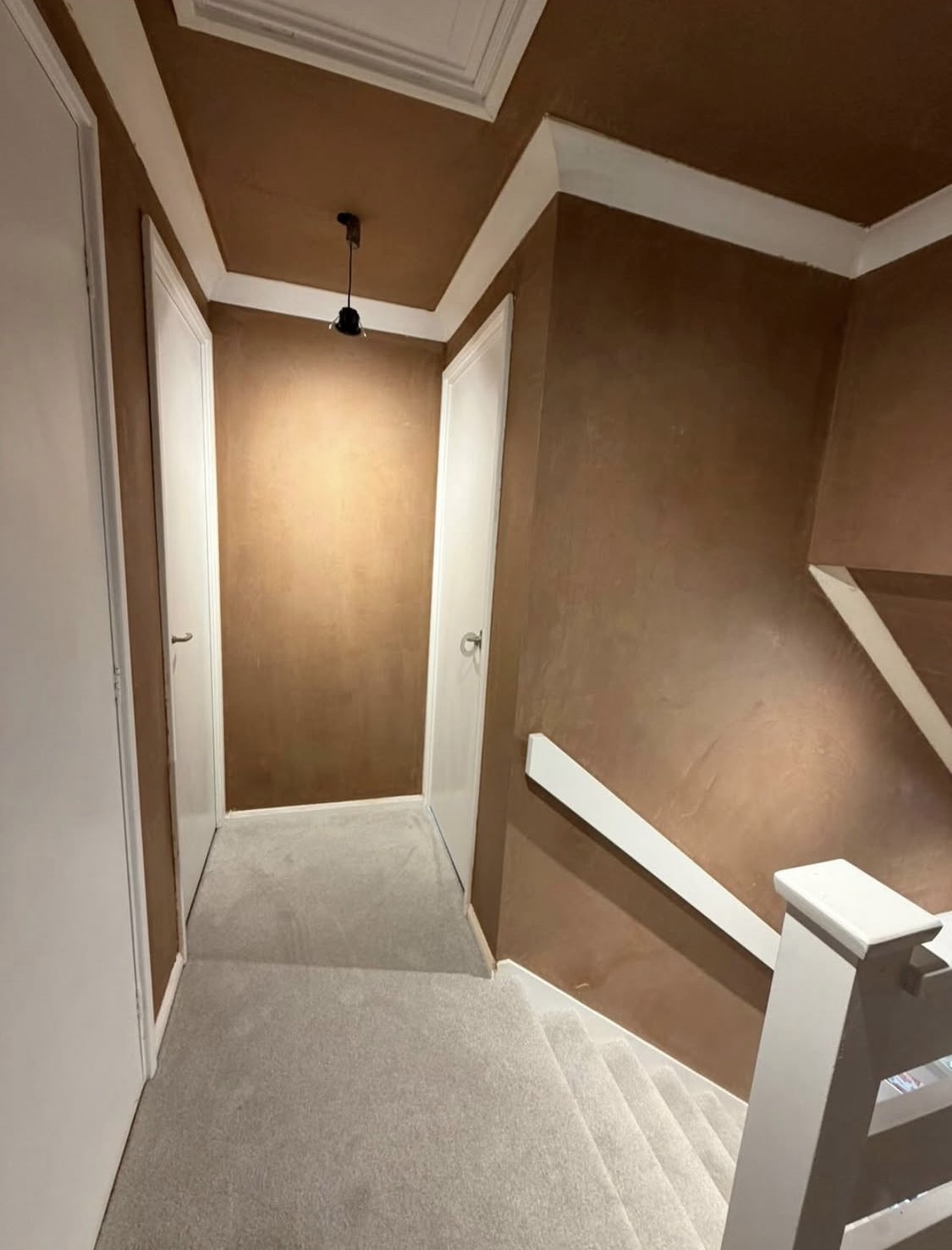 After: hallway freshly plastered in a warm mocha finish