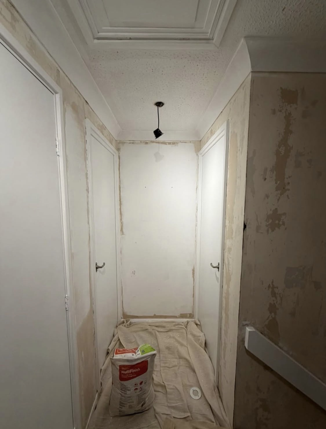 Before: hallway stripped back before a full re-plaster