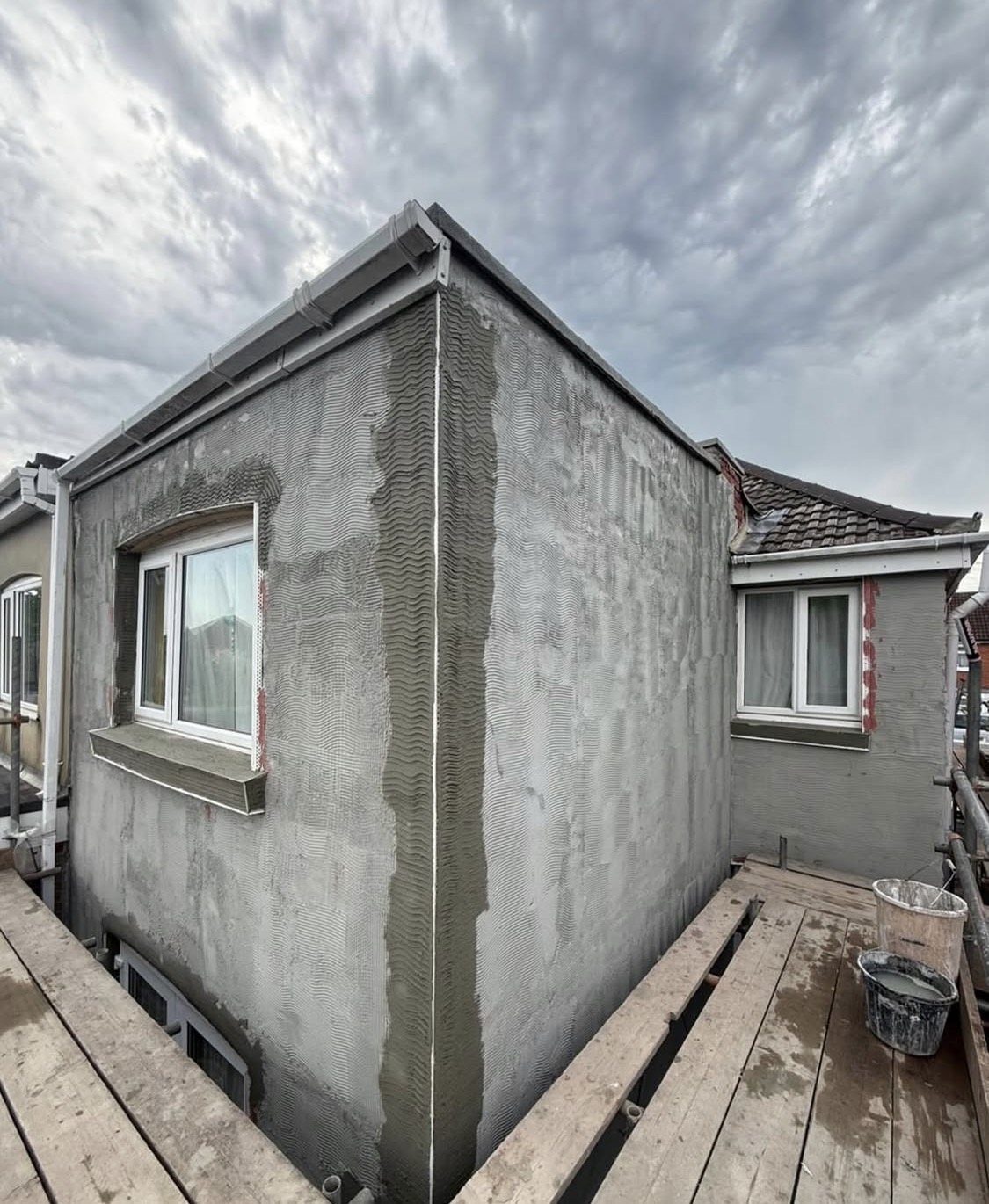 During: base coat render being worked over the extension walls